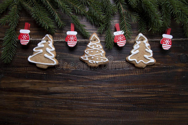 圣诞背景是用糖霜装饰的<strong>饼干</strong>，在<strong>木板上</strong>有衣夹和手套。