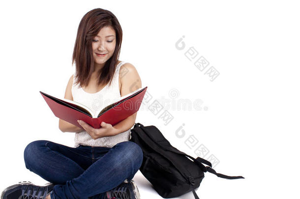 美丽的亚洲年轻女子背着书包读红皮书
