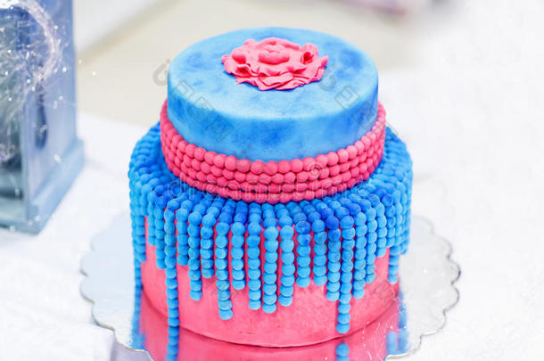 蓝色和红色或粉色的结婚蛋糕。带着优雅的珍珠