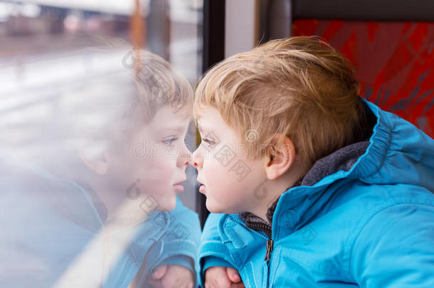 可爱的孩子在火车窗外旅行和看窗外