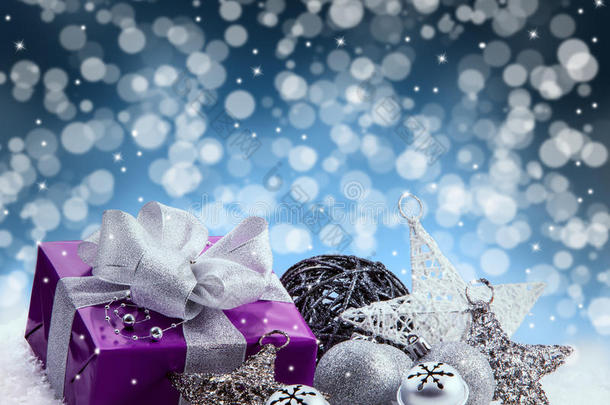 紫色圣诞<strong>礼包</strong>，银丝带礼物。铃铛叮当作响，银色圣诞球和圣诞星星放在雪地上。