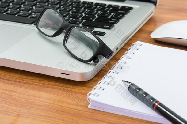 空白商务笔记本电脑、鼠标、笔、便条和眼镜