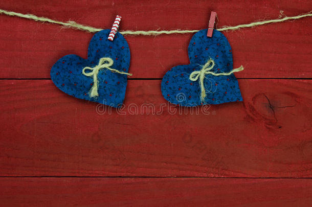 古色古香的红色木质背景，挂在晾衣绳上的蓝色乡村心形图案
