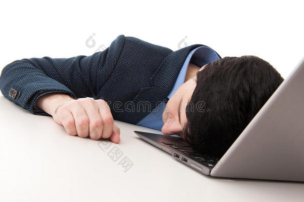 劳累过度的商人睡在笔记本电脑上