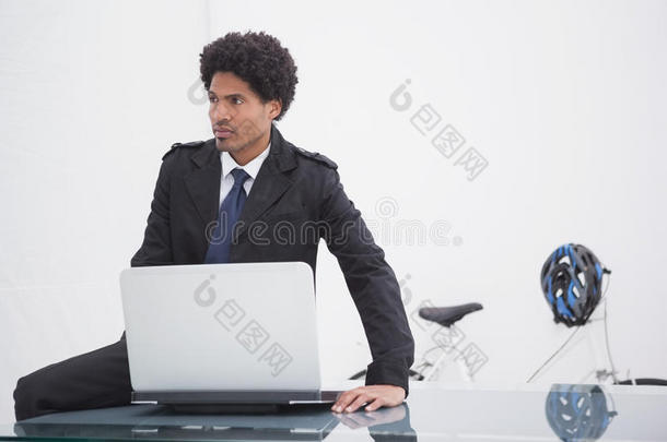 体贴的商人穿着<strong>风衣</strong>用笔记本电脑