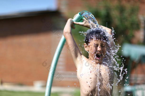 炎炎夏日，男孩拿着泼水