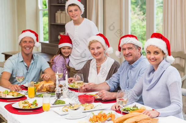 圣诞节期间，一家人戴着圣诞帽看着摄像机