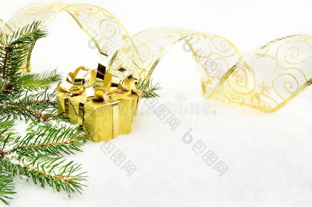 金色圣诞礼物，金色丝带和针杉在雪上