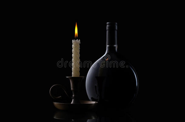 黑色背景的酒瓶、蜡烛和酒杯