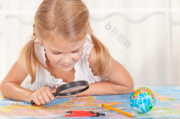 小女孩正拿着放大镜看世界地图