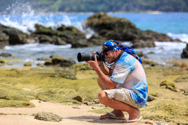 沙滩上带单反相机的男摄影师