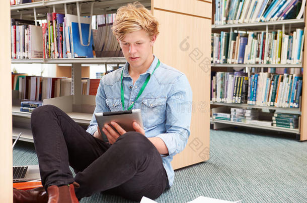 男大学生在图书馆用数字平板电脑学习