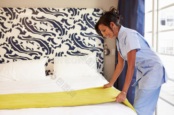 女佣整理酒店房间，整理床铺
