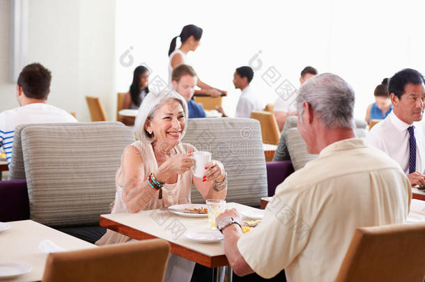 在酒店餐厅享用早餐的老年夫妇