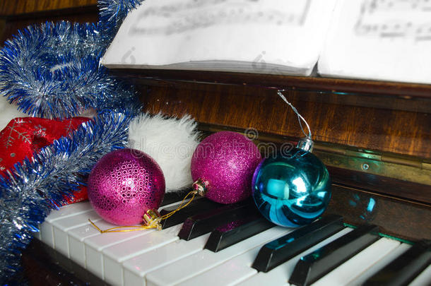 圣诞老人的帽子和圣诞装饰品放在钢琴上。