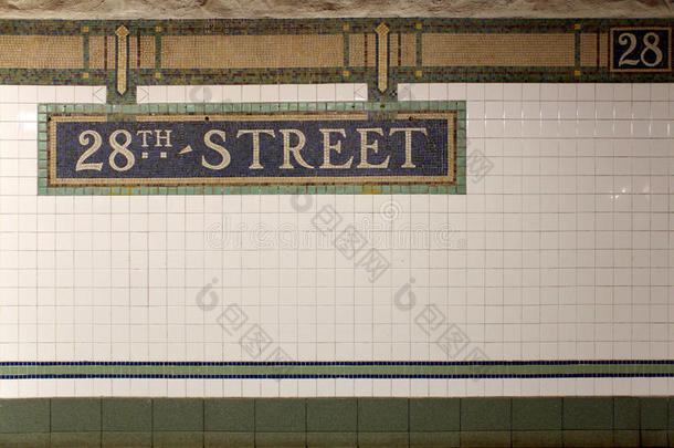 纽约市地铁28号街标志贴在瓷砖墙上。