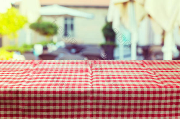 模糊餐厅背景上有红色格子桌布的桌子