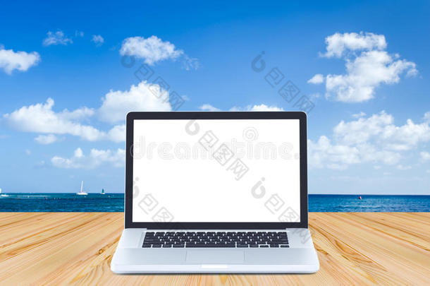 木质地板上的空白屏幕笔记本电脑，带有海洋和蓝色