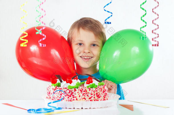 白色背景上拿着生日蛋糕和气球的小男孩