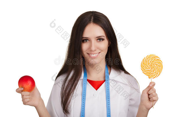营养学家拿着一个苹果和一个大糖果
