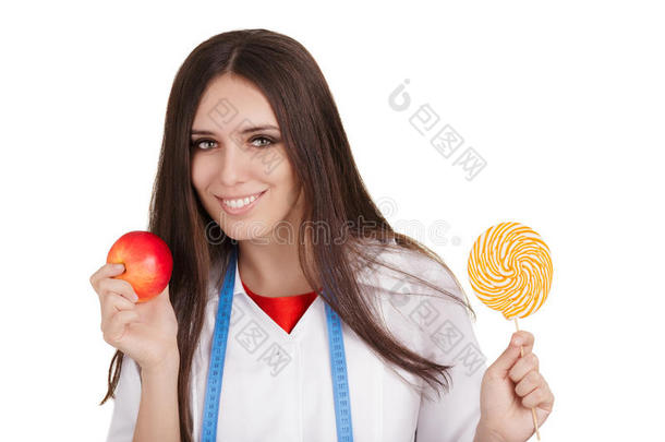 营养学家拿着一个苹果和一个大糖果