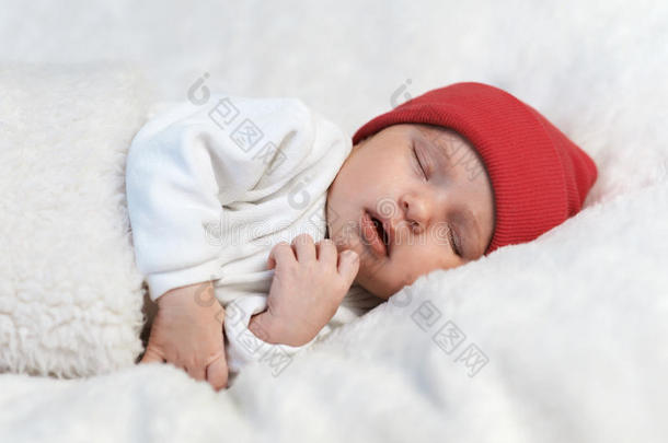 婴儿睡在白色的红帽子里