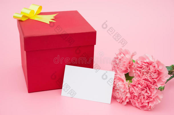红色礼品盒和粉色康乃馨，还有一张空白卡片