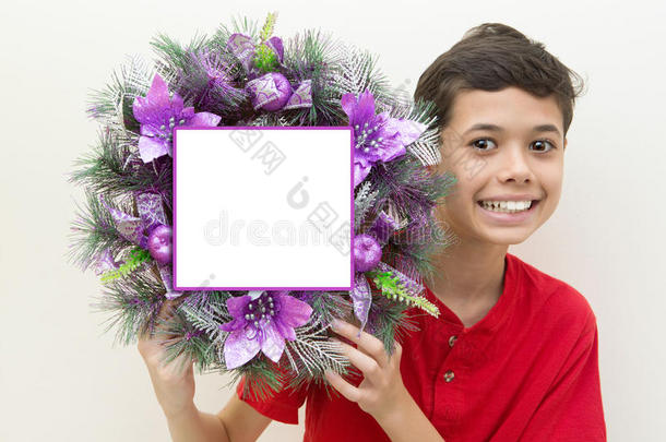 男孩兴奋地<strong>拿着</strong>紫色的圣诞<strong>花环</strong>。