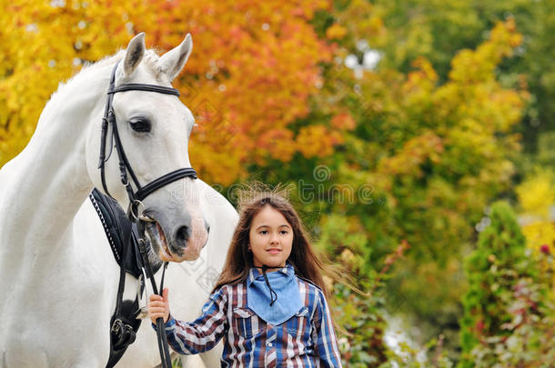 骑着白色盛装舞步马的年轻女孩