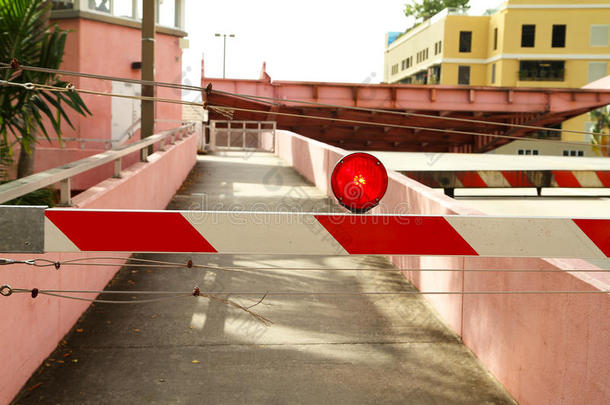 一座露天吊桥前闪烁的红色路障灯