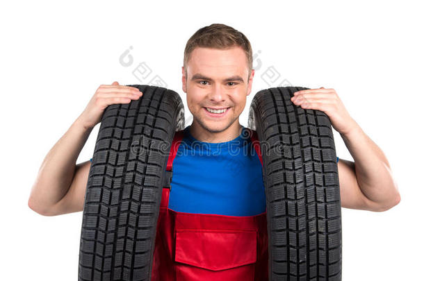汽车修理工在白色背景上带着两个轮胎。