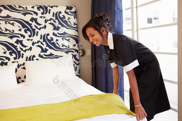 女佣整理酒店房间，整理床铺
