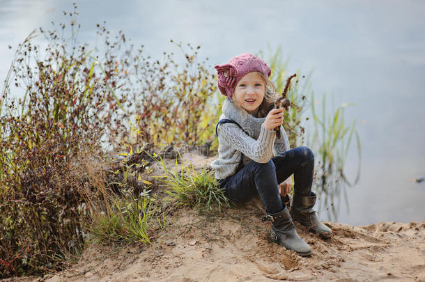 可爱快乐的小女孩在秋天的河边玩耍