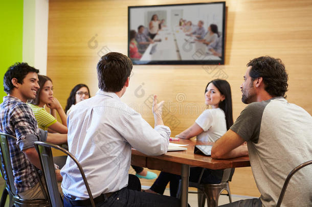 设计师们围坐在会议桌旁看着屏幕