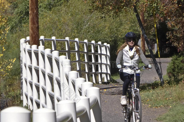 一个女自行车手在秋天骑车