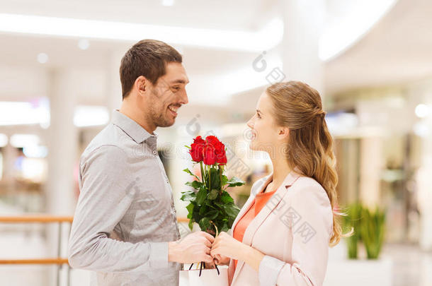 <strong>商场</strong>里有鲜花的快乐的年轻夫妇