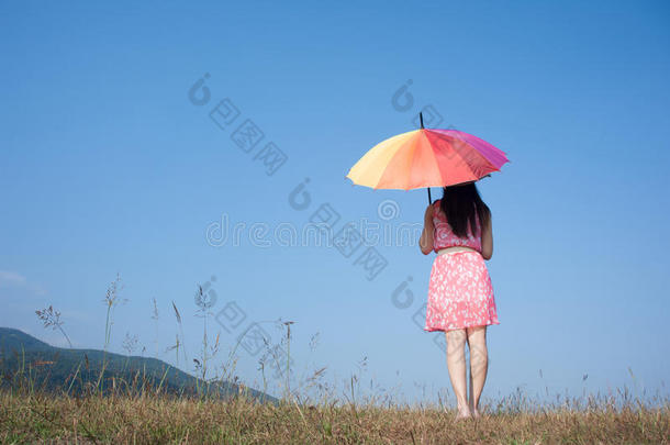 在美丽的日子里，女人撑着伞站在天空中放松