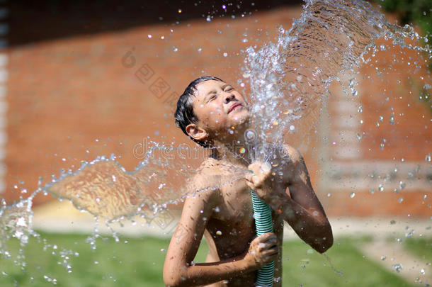 炎炎夏日，男孩拿着泼水
