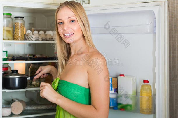 一个金发女人在冰箱旁边