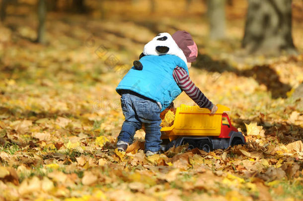 这孩子在秋天公园玩玩具机