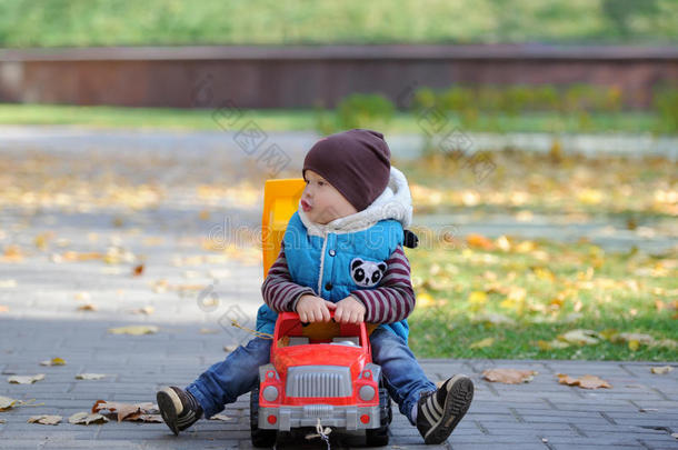 这孩子在秋天公园玩玩具机