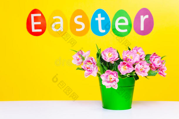 桌上的绿色花盆里有粉红色的花，有复活节的字样