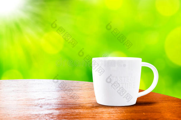 木质圆桌，白色杯子，绿色背景