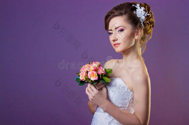 一个美丽的温柔优雅的女孩新娘穿着白色的裙子，美丽的发型和美丽的妆容