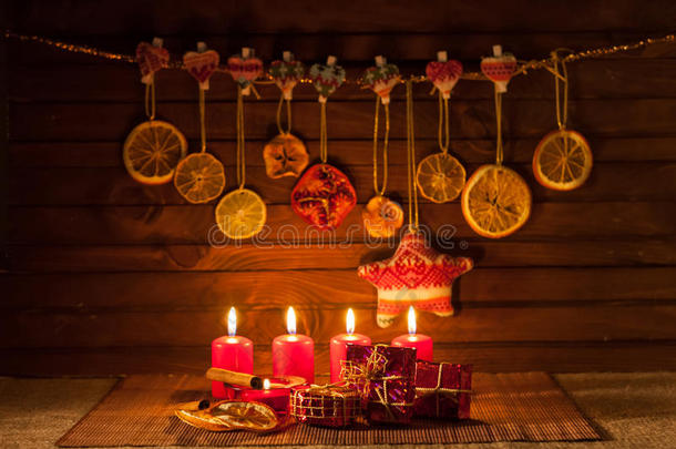棕色背景上的圣诞装饰品、蜡烛、礼物的图片