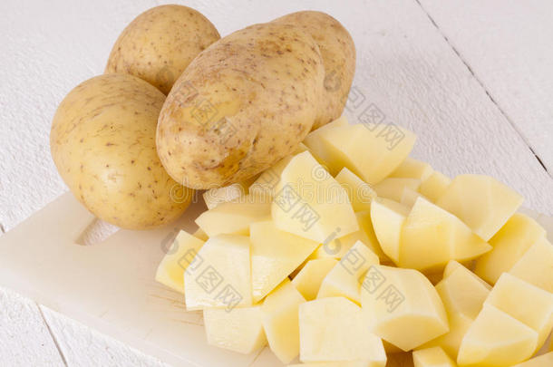 整个土豆和切碎的土豆块放在砧板上