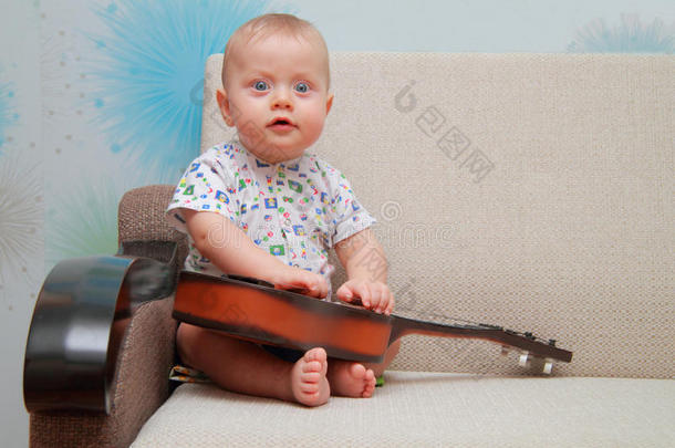 宝宝试着在沙发上弹吉他
