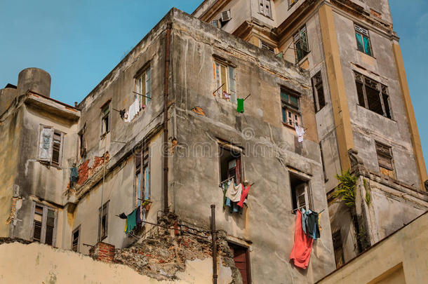 古巴哈瓦那大街上，蓝天映衬下，古色古香的复古建筑，敞开的窗户里摆着各种各样的衣服