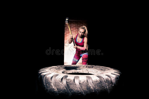 健身大<strong>锤</strong>女子训练健身大<strong>锤</strong>用<strong>锤</strong>子和拖拉机轮胎在健身房锻炼。