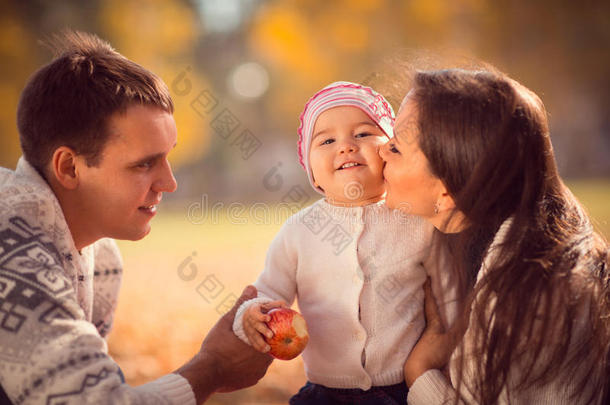 快乐的年轻家庭在秋天的公园里度<strong>过户</strong>外时光